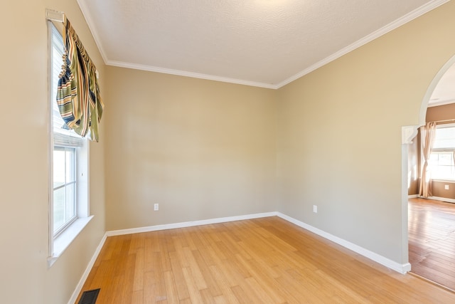 unfurnished room with crown molding, a textured ceiling, and wood-type flooring