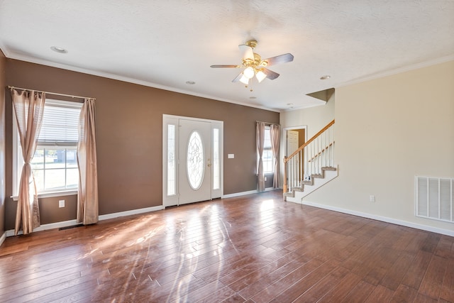 foyer with crown molding, hardwood / wood-style flooring, a wealth of natural light, and ceiling fan