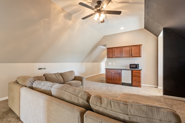 carpeted living room featuring ceiling fan and vaulted ceiling