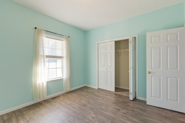 unfurnished bedroom with a closet and wood-type flooring