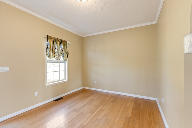 empty room with light hardwood / wood-style floors, crown molding, and a textured ceiling