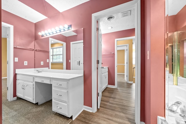 bathroom featuring vanity, a textured ceiling, and hardwood / wood-style flooring