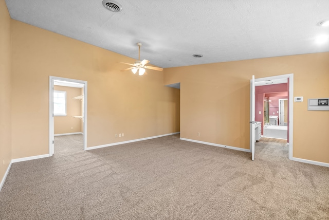 spare room with light carpet, a textured ceiling, and ceiling fan