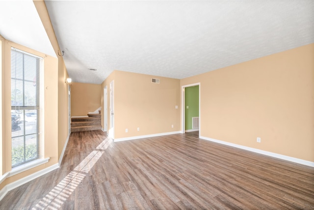 spare room featuring hardwood / wood-style floors and a textured ceiling