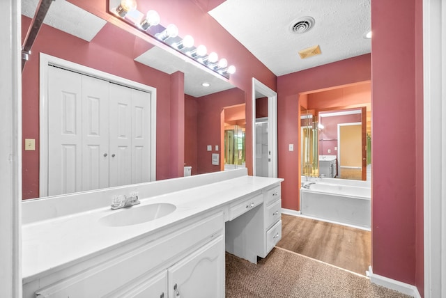 bathroom with vanity, a textured ceiling, independent shower and bath, and wood-type flooring