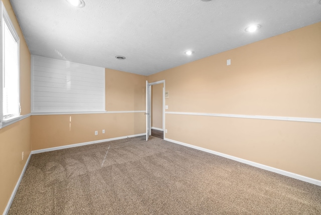 carpeted spare room with a textured ceiling