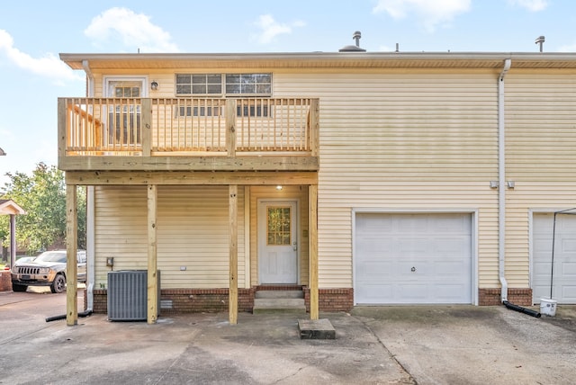 exterior space featuring central AC unit, a garage, and a balcony