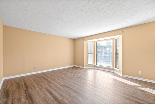 unfurnished room featuring hardwood / wood-style flooring and a textured ceiling