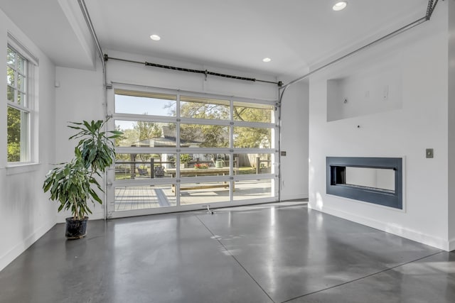 unfurnished living room with a healthy amount of sunlight and concrete floors