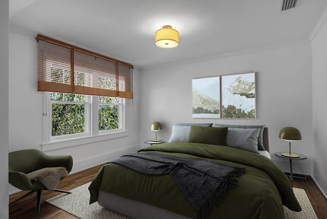 bedroom with ornamental molding and dark hardwood / wood-style flooring