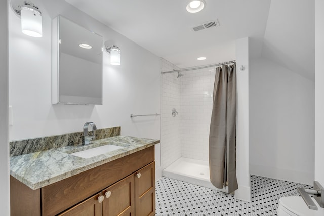 bathroom featuring walk in shower, vanity, and toilet