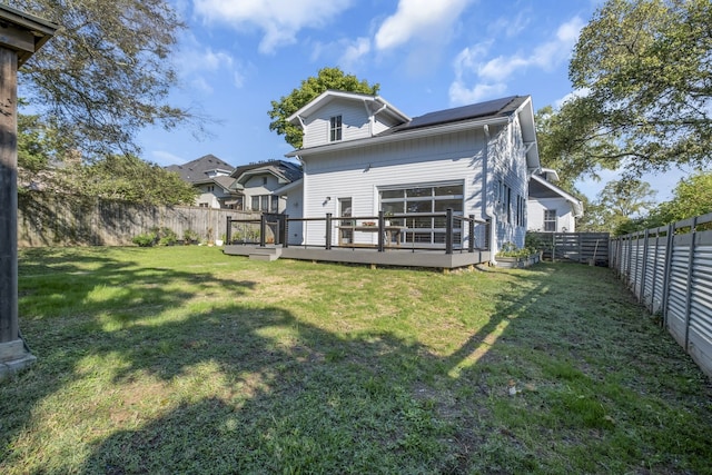 back of property with a lawn and a deck