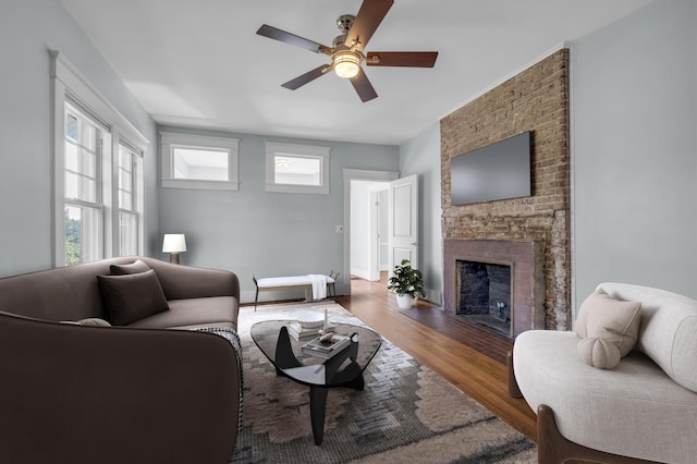 living room with hardwood / wood-style flooring, a fireplace, and ceiling fan