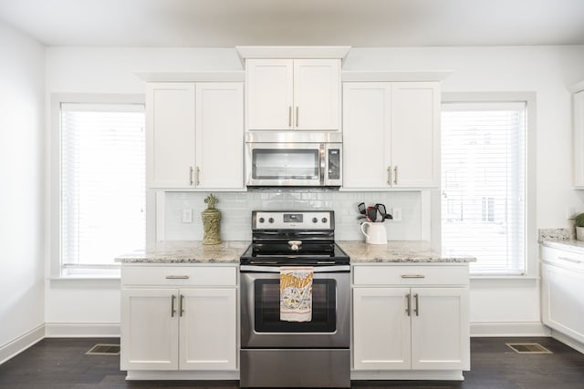 kitchen with stainless steel appliances, dark wood-type flooring, light stone counters, and white cabinetry