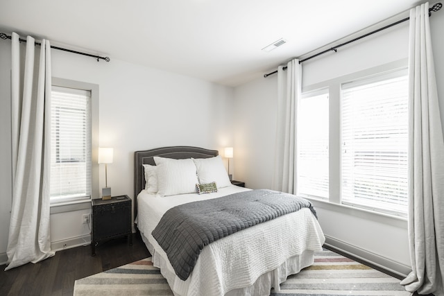 bedroom featuring multiple windows and dark hardwood / wood-style floors