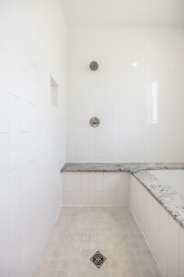 bathroom featuring a tile shower and tile patterned flooring