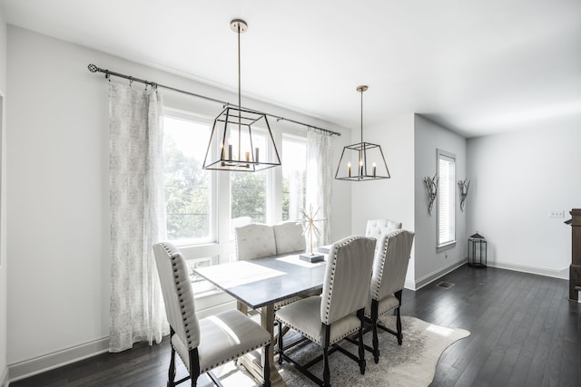 dining area with dark wood-type flooring and a notable chandelier