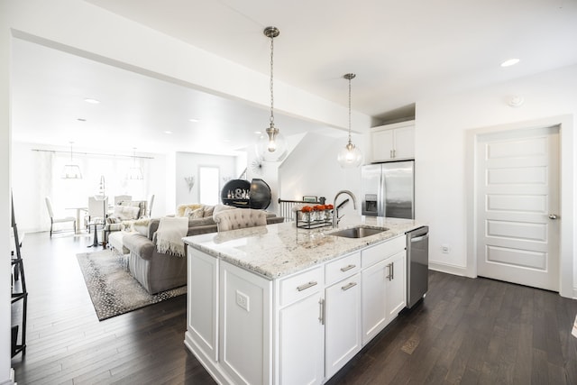 kitchen with white cabinets, an island with sink, appliances with stainless steel finishes, and sink