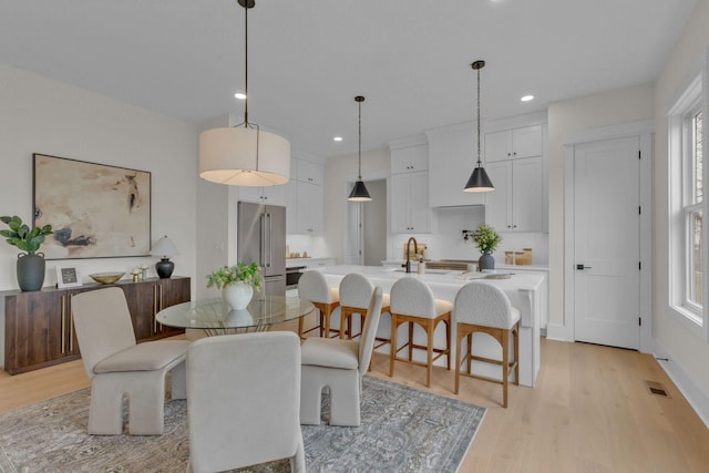 dining space featuring sink and light hardwood / wood-style floors