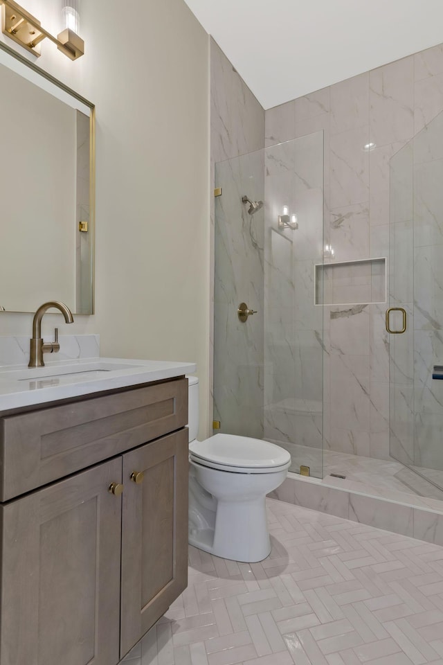 bathroom with vanity, a shower with shower door, and toilet