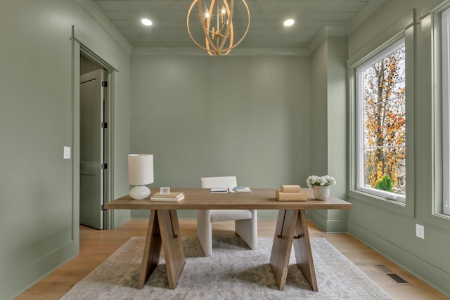 office space featuring crown molding, light hardwood / wood-style flooring, and a chandelier