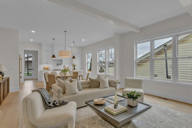 living room featuring light hardwood / wood-style floors and beamed ceiling