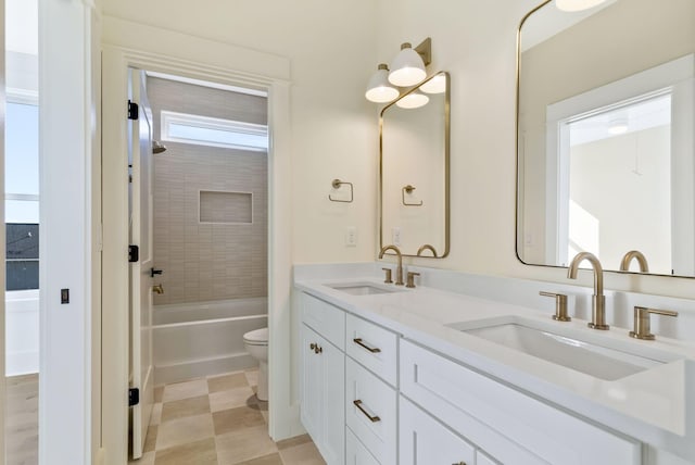 full bathroom featuring tiled shower / bath combo, vanity, and toilet