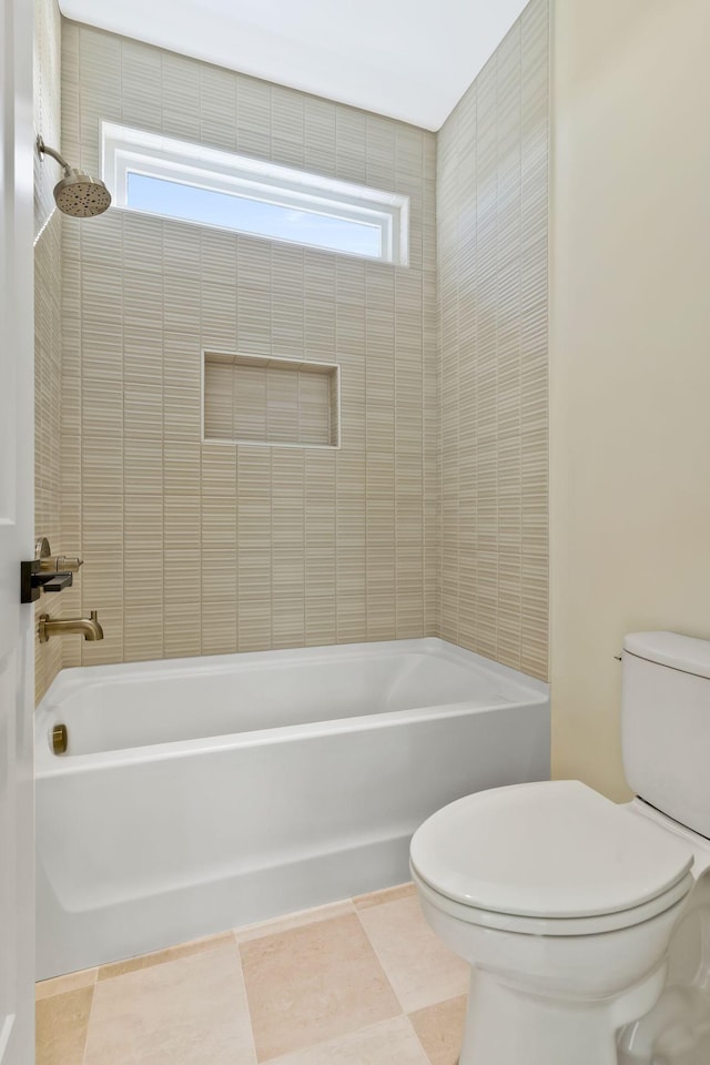 bathroom with tiled shower / bath, a healthy amount of sunlight, and toilet