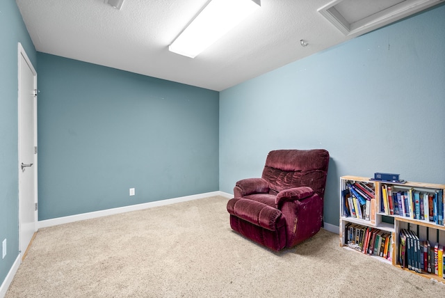 sitting room featuring carpet floors and a textured ceiling