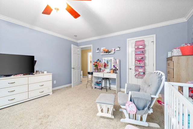 bedroom featuring a nursery area, ceiling fan, crown molding, and light colored carpet