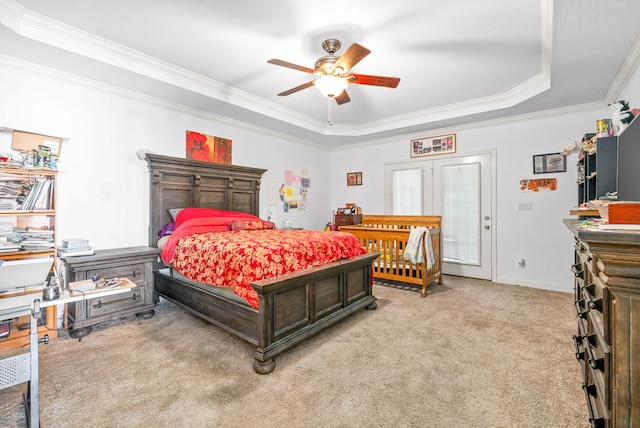 bedroom with ceiling fan, french doors, a raised ceiling, ornamental molding, and light colored carpet