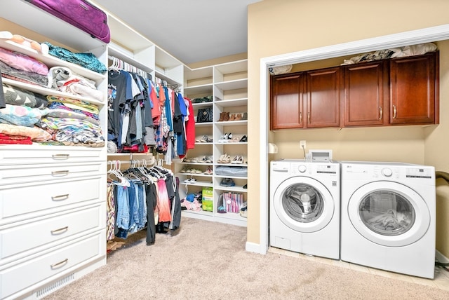 washroom featuring light colored carpet, cabinets, and washer and clothes dryer