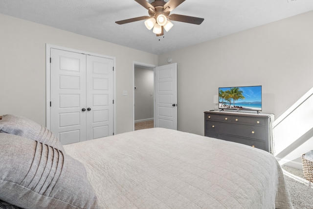 carpeted bedroom with a closet, a textured ceiling, and ceiling fan