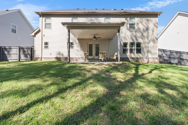 back of house featuring ceiling fan, a patio, and a lawn