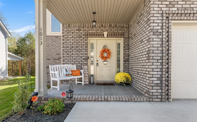 doorway to property featuring a garage and a porch