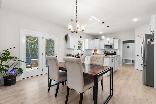 dining space featuring light hardwood / wood-style floors and a chandelier