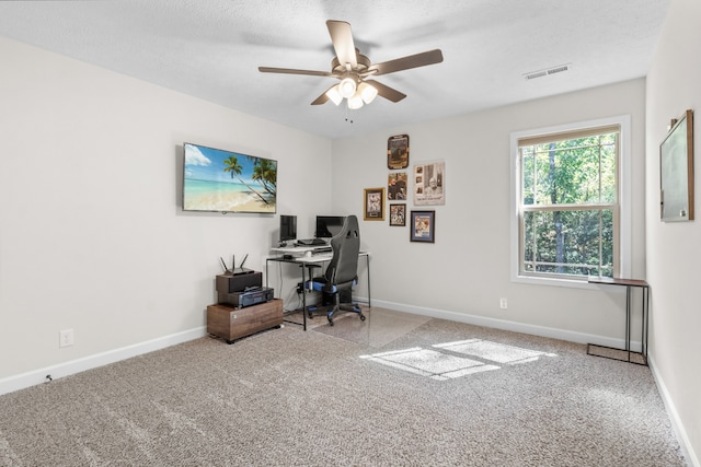 office area featuring carpet flooring, ceiling fan, and a textured ceiling