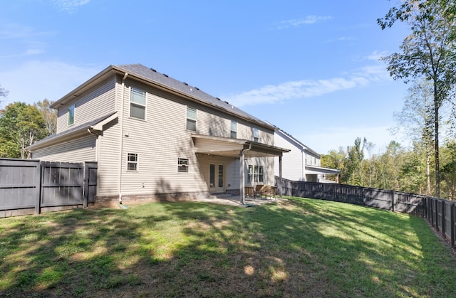 back of house with a yard and a patio