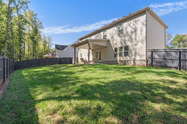 back of house with a patio and a yard