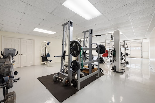 exercise room with a paneled ceiling and concrete flooring