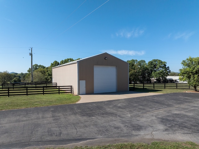 view of outdoor structure with a garage and a lawn