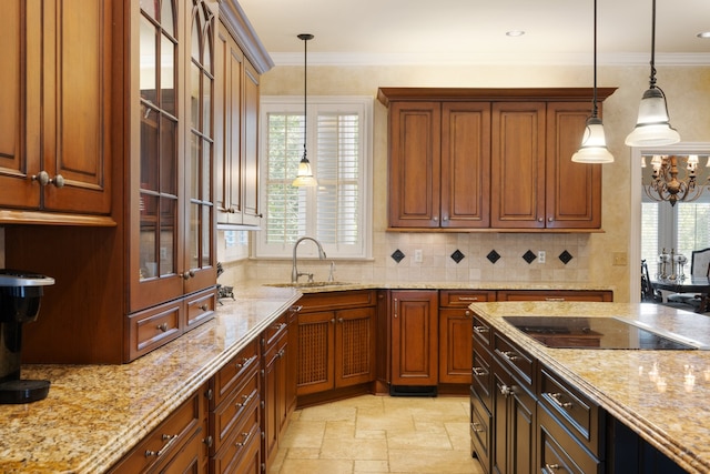 kitchen with a healthy amount of sunlight, crown molding, hanging light fixtures, and sink