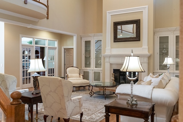 living area featuring a high ceiling, a fireplace, and wood-type flooring