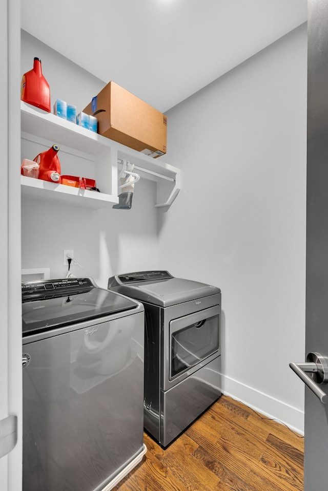 washroom featuring hardwood / wood-style flooring and washing machine and clothes dryer