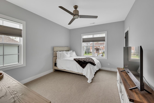 bedroom featuring carpet, multiple windows, and ceiling fan