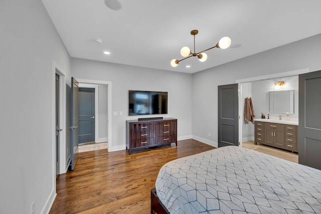 bedroom featuring ensuite bathroom, a chandelier, and dark hardwood / wood-style flooring