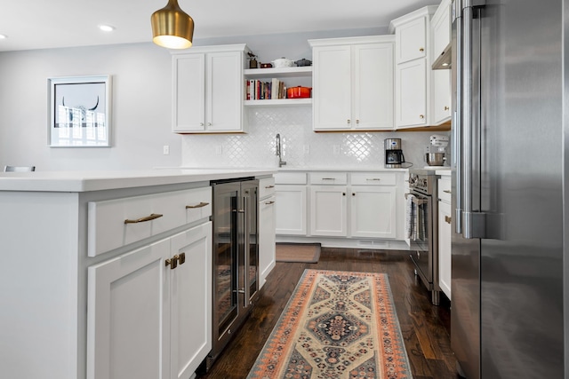 kitchen with wine cooler, appliances with stainless steel finishes, dark hardwood / wood-style flooring, and white cabinetry