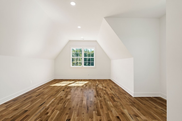 additional living space featuring lofted ceiling and dark hardwood / wood-style flooring