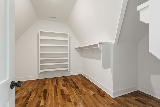 walk in closet featuring dark wood-type flooring and vaulted ceiling