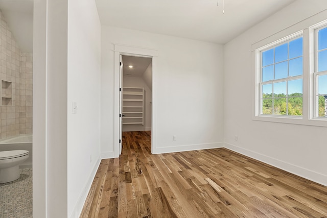 spare room featuring light wood-type flooring and vaulted ceiling